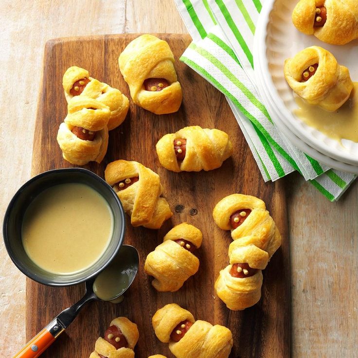 hotdogs wrapped in crescented bread with ketchup on a cutting board