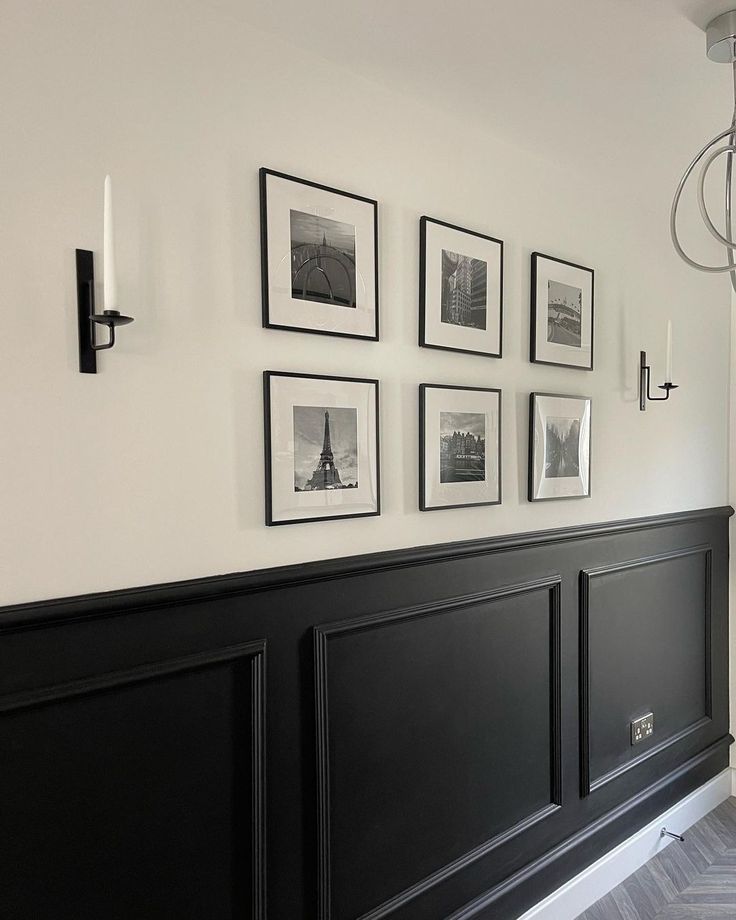 a black headboard with pictures on the wall and chandelier hanging above it