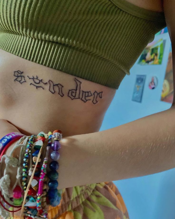 a woman with a tattoo on her stomach and bracelets around her waist that says, be kinder