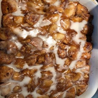 a casserole dish with cinnamon rolls covered in icing