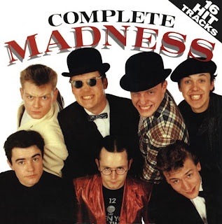 a group of men standing next to each other in front of a white sign that says complete madness