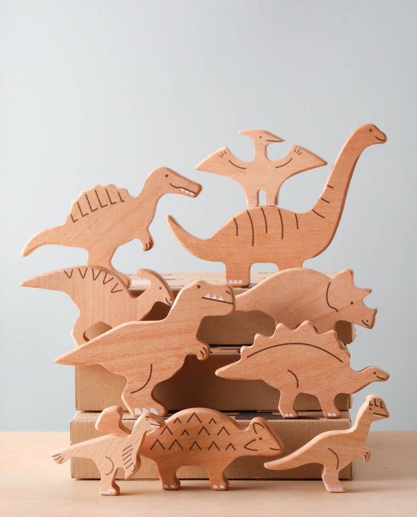 wooden toy dinosaurs in a box on a table