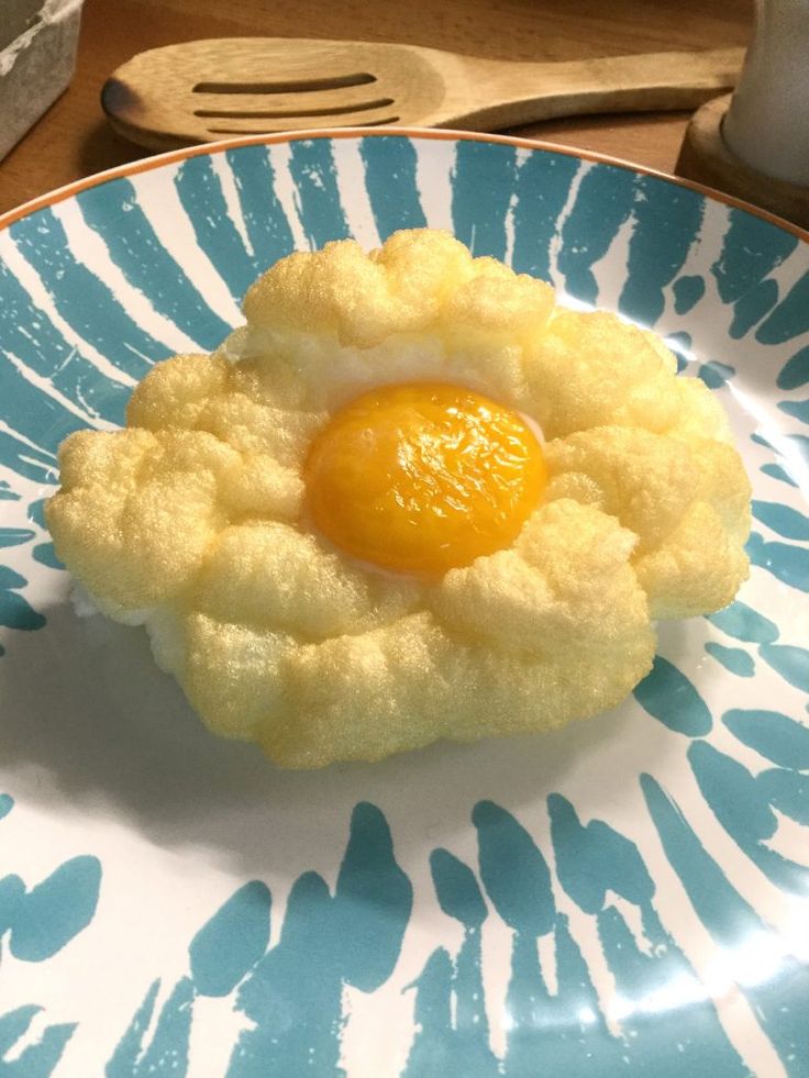 an egg in the middle of a pastry on a blue and white plate