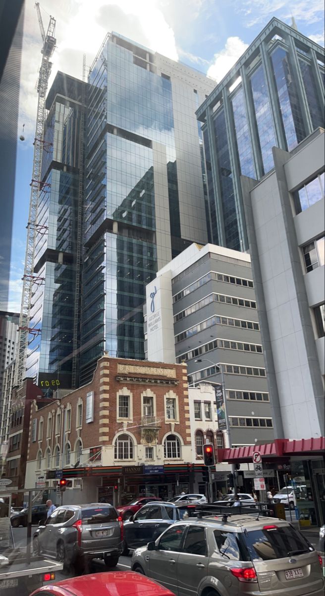 a city street filled with lots of traffic next to tall buildings