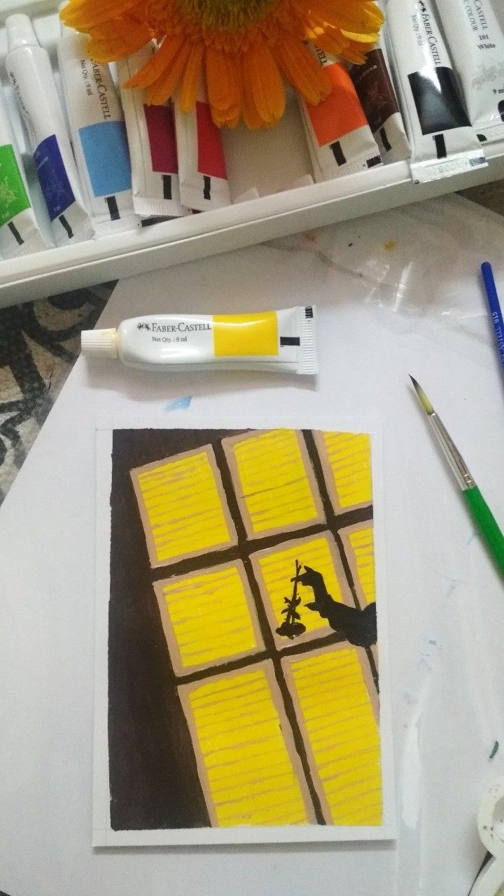 a sunflower sitting on top of a table next to some markers and paintbrushes