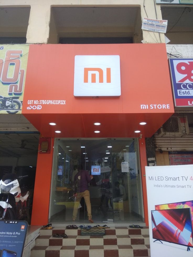 the entrance to a store with an orange and white sign above it that says mi led smart tv