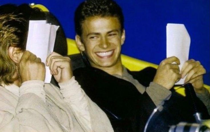 two people sitting next to each other holding papers