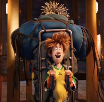 a boy with red hair sitting in a chair and holding onto the back of his backpack