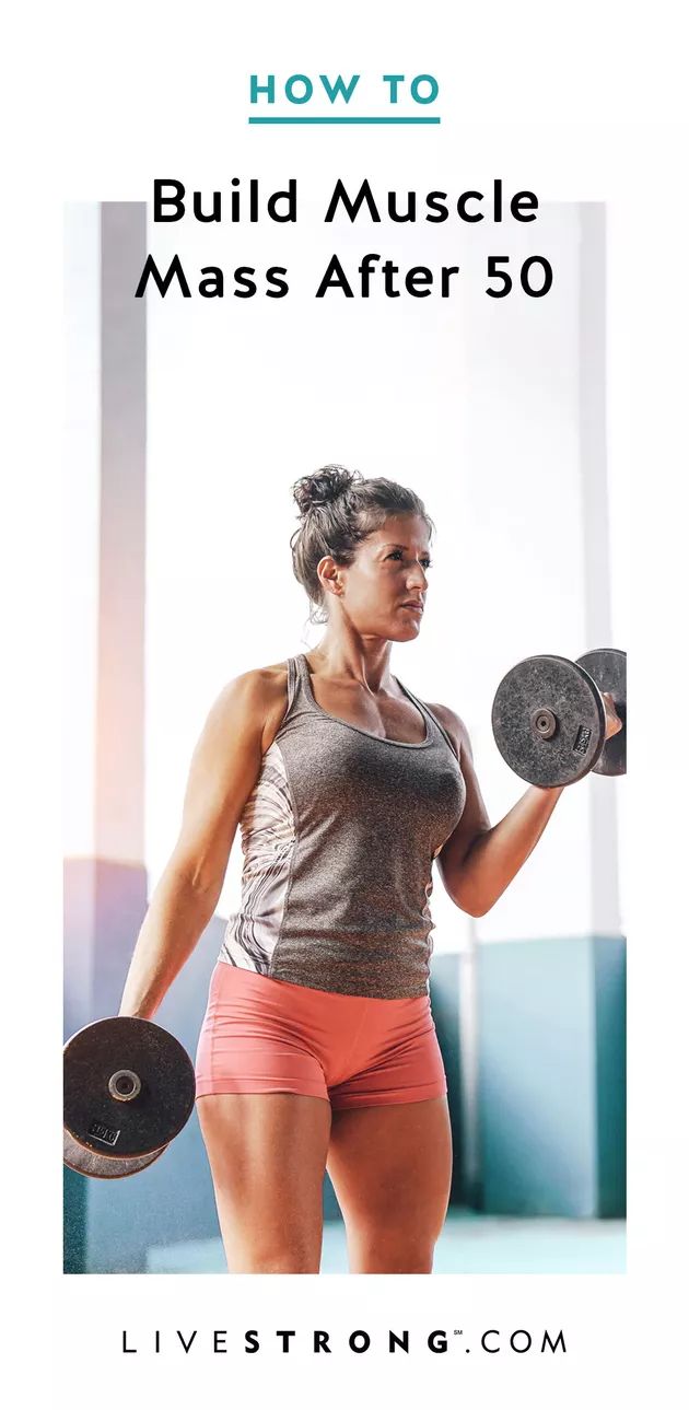 a woman holding two dumbs in her hands and the words how to build muscle mass after 50