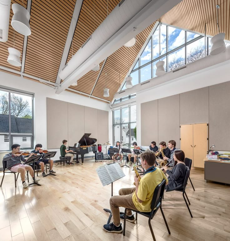 a group of people sitting in chairs around a table with musical instruments on the floor