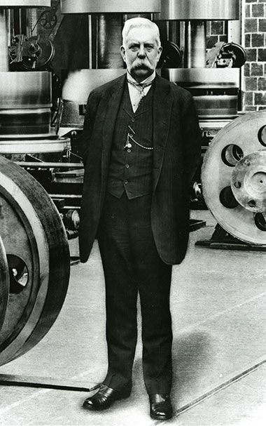 an old photo of a man standing in front of some machines