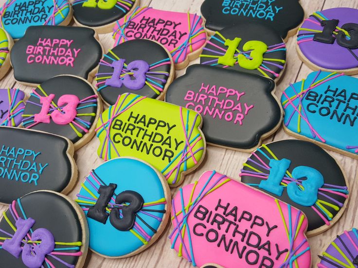 decorated cookies are arranged on a table for a 30th birthday party with neon and black icing