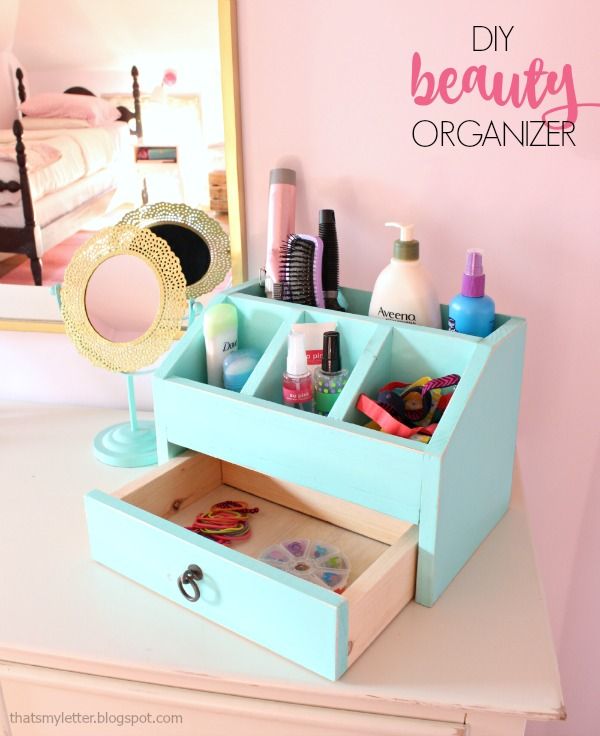 an organized makeup organizer on a dresser in a girls bedroom with pink walls and white bedding