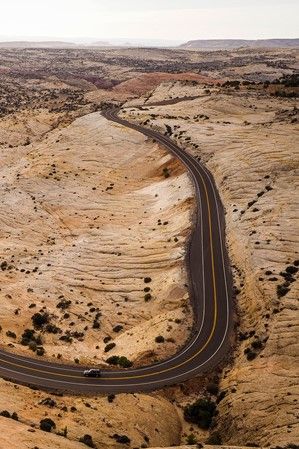 an aerial view of a winding road in the desert