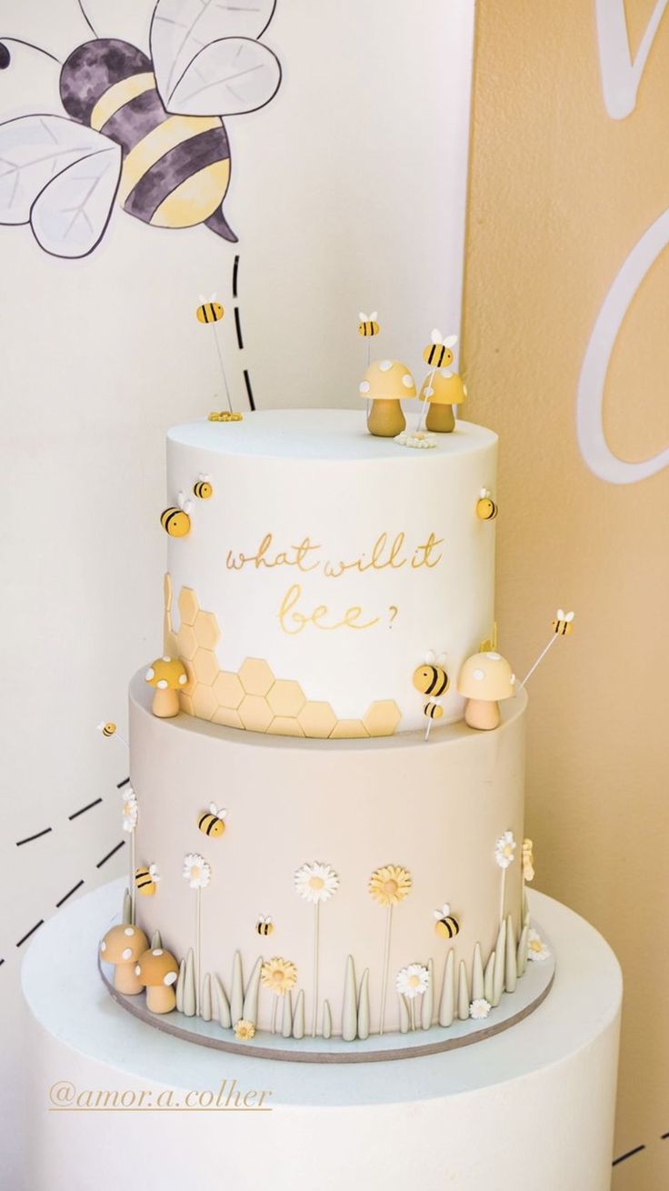 a three tiered cake with bees on top