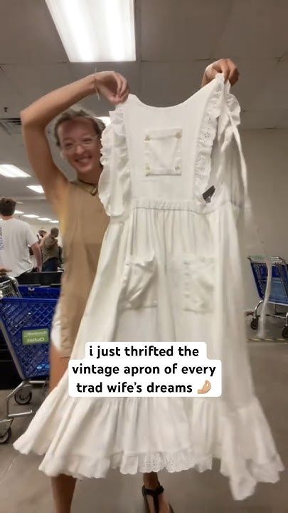 a woman holding up a white dress with the words, i just tried the vintage apron of every trade we're dreams