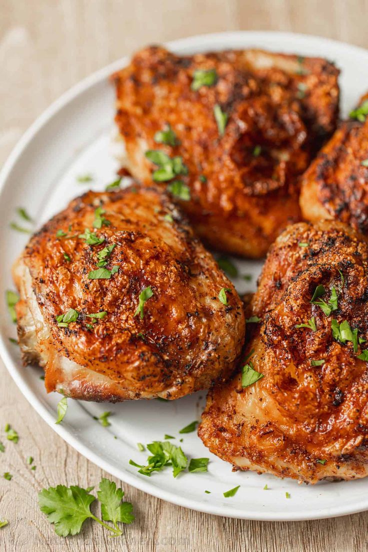 some chicken on a white plate with parsley