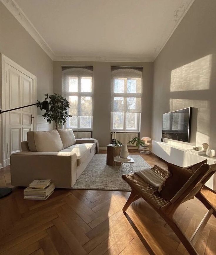 a living room filled with furniture and a flat screen tv on top of a wooden floor