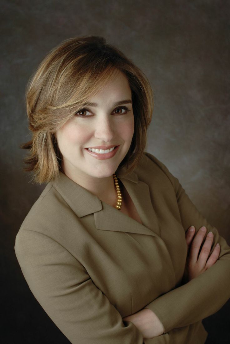 a woman with her arms crossed posing for a photo