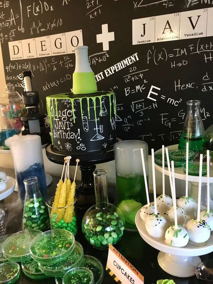 an assortment of desserts and candies are on display in front of a chalkboard