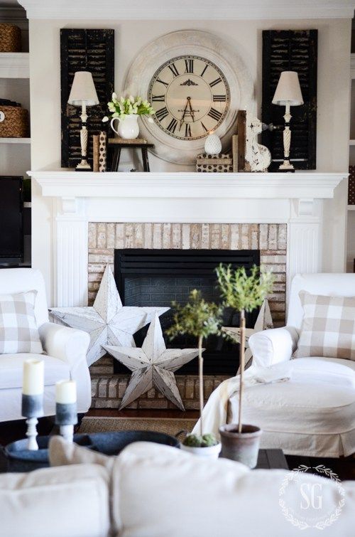 a living room filled with furniture and a large clock on the wall above the fireplace