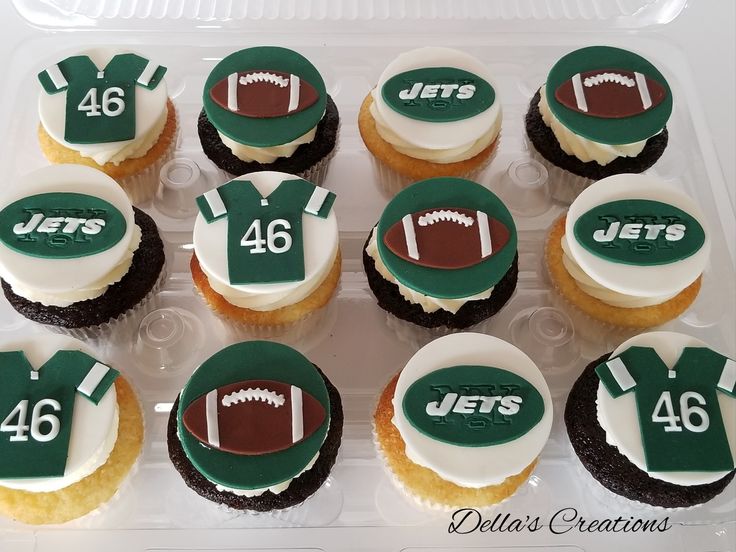 cupcakes decorated with green and white frosting are in a plastic container on the table