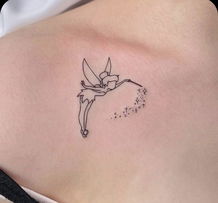 a small tattoo on the back of a woman's stomach, depicting a fairy