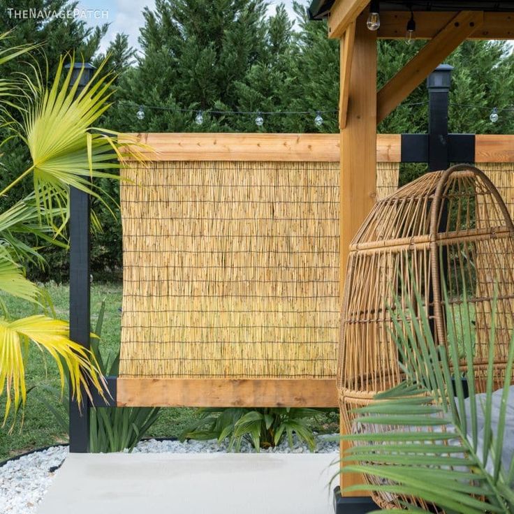 a birdcage sitting on top of a cement floor next to a wooden fence