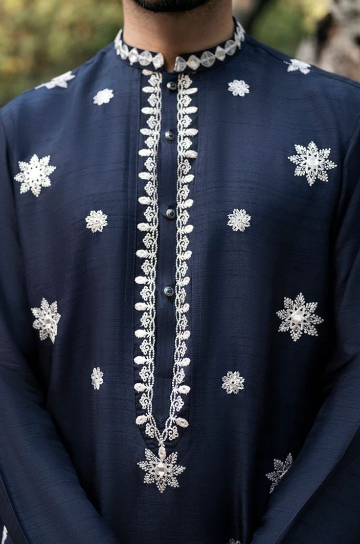 Introducing our navy blue men's kurta, a true work of art in terms of composition and design. The kurta features an intricate embroidery of sheesha booti on the front, adding a touch of traditional elegance that is sure to turn heads. The deep navy blue shade of the fabric gives a sense of sophistication to the overall look, making it perfect for any occasion. The kurta is accompanied by a plain trouser, creating a perfect ensemble for your wardrobe. With its impeccable craftsmanship and attention to detail, this kurta is the perfect addition to your wardrobe, providing a sense of majestic aesthetic splendor that is second to none. Luxury Men's Salwar Kameez With Resham Embroidery, Luxury Men's Salwar Kameez With Intricate Embroidery, Luxury Men's Salwar Kameez With Zari Work, Luxury Men's Kurta With Intricate Embroidery, Luxury Men's Traditional Wear With Printed Motifs, Luxury Men's Traditional Wear With Embroidered Border, Luxury Semi-stitched Men's Traditional Wear, Luxury Elegant Men's Kurta, Luxury Men's Traditional Fit Kurta