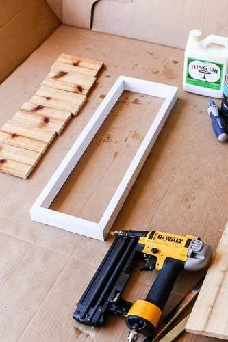 some tools are laying out on the floor next to boxes and plywood planks