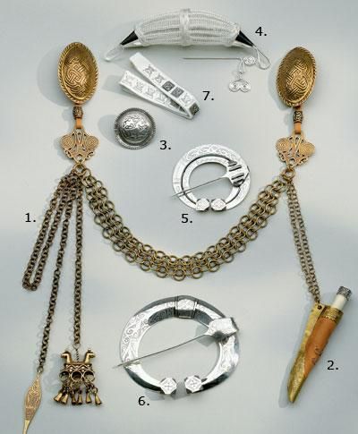 an assortment of jewelry is displayed on a white surface with gold chains and other items