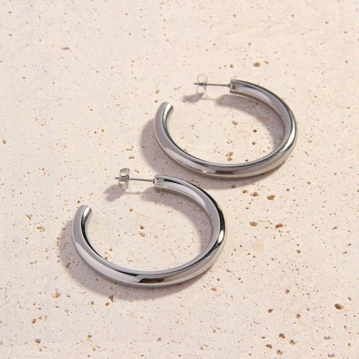 Our new 925 Plated Cali Silver Hoops are the ideal everyday hoops. Perfectly weighted and designed with simple and clean lines, these mid-sized silver hoops take you from day to night with ease. They’ll look amazing with your favorite silver jewellery pieces. We love pairing the Cali Silver Hoops with a striped rugby shirt, lace tank top and jeans. They also go beautifully with evening wear. These classic earrings are an essential addition to your jewellery collection!  Details:   4.5cm Diameter Minimalist Metal Hoop Earrings With Shiny Finish, Sterling Silver Minimalist Hoop Earrings With Shiny Finish, Silver Minimalist Hoop Earrings With Polished Finish, Minimalist Silver Hoop Earrings With Polished Finish, Minimalist Hoop Earrings With Shiny Finish, Everyday White Gold Metal Hoop Earrings, Silver Minimalist Hoop Earrings, Minimalist Metal Hoop Earrings With Polished Finish, Small Silver Hoop Earrings With Shiny Finish