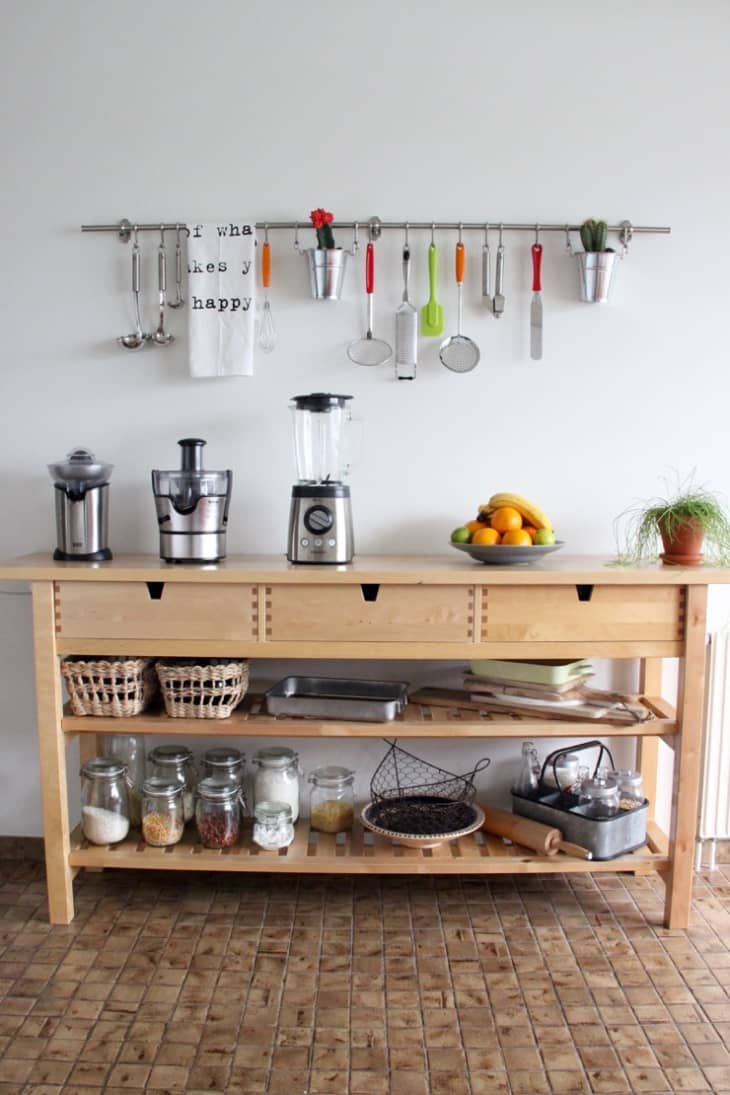 a kitchen counter with pots and pans hanging on the wall next to utensils