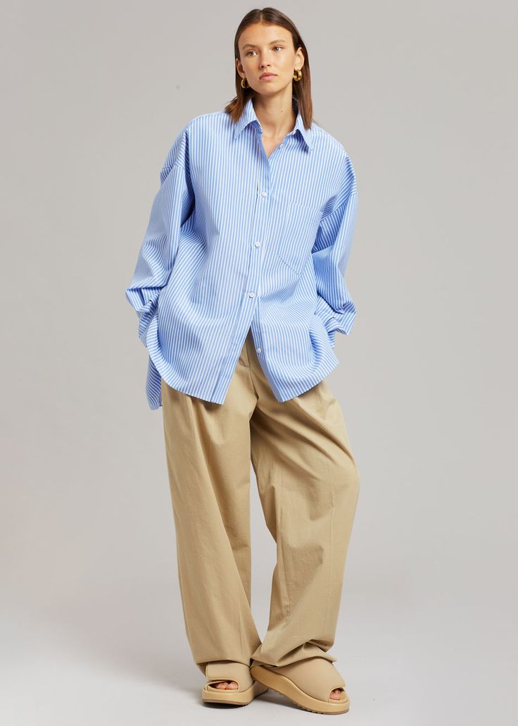 Color: White/Light Blue Lightweight shirting fabric Oversized fit Pointed collar Single breast pocket High-low curved hem Button front closure 100% Cotton Dry Clean By The Frankie Shop. Imported Product Measurements: XS/S - 24" Shoulder, 56" Bust, 31" Length M/L - 25" Shoulder, 59" Bust, 31.5" Length Model is 174cm/ 5'8" wearing size M/L Oversized Light Blue Shirt With Pockets, Relaxed Fit Light Blue Blouse With Pockets, Blue Shirt With Placket And Shirttail Hem, Oversized Light Blue Tops With Pockets, Blue Work Shirt With Pockets, Blue Workwear Shirt With Pockets, Blue Shirt With Pockets And Lapel Collar, Blue Office Shirt With Pockets, Light Blue Workwear Shirt With Pockets