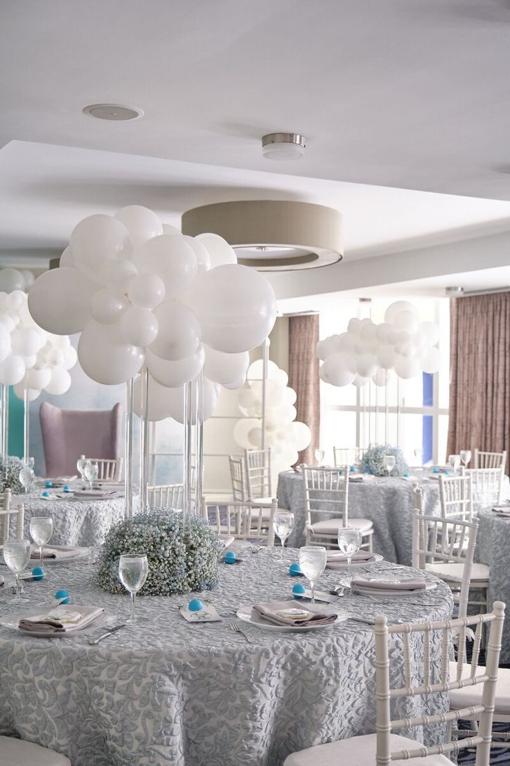 the tables are set with white balloons and place settings