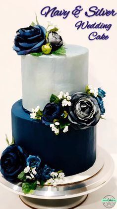 a wedding cake decorated with blue flowers and greenery