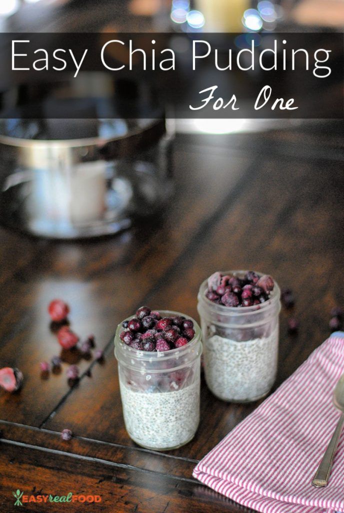 two jars filled with blueberries sitting on top of a table next to a spoon