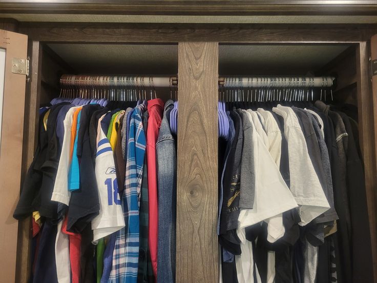 a closet filled with lots of different colored shirts