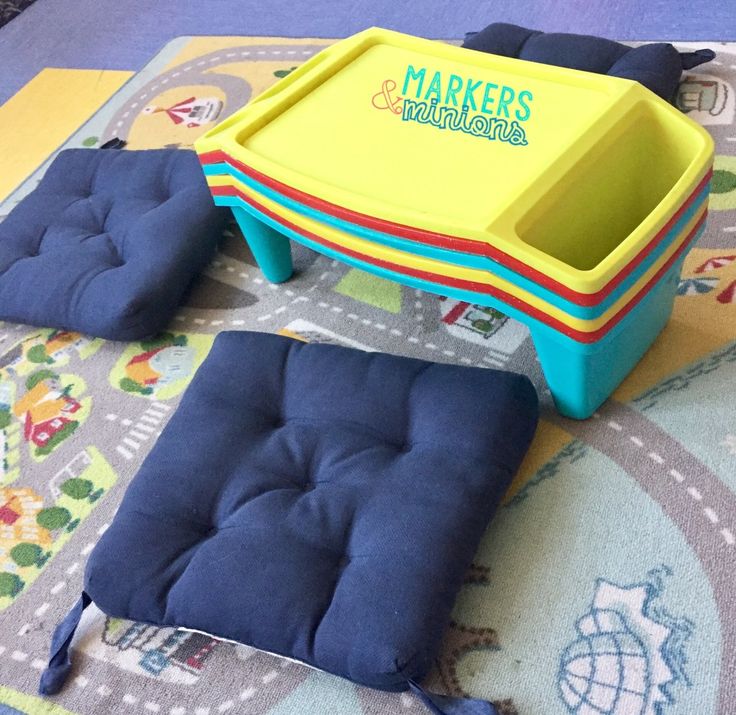 a blue and yellow toy truck sitting on top of a colorful rug next to other toys