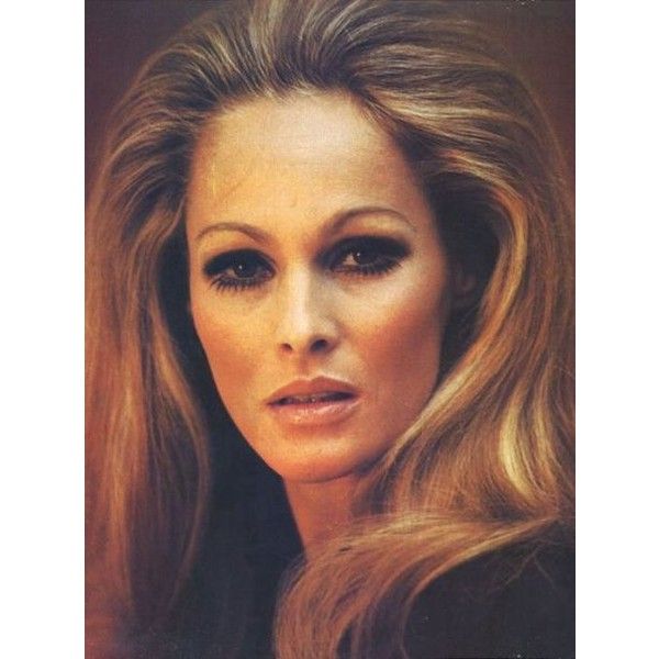 an old photo of a woman with long blonde hair and black eyeshadow, looking at the camera