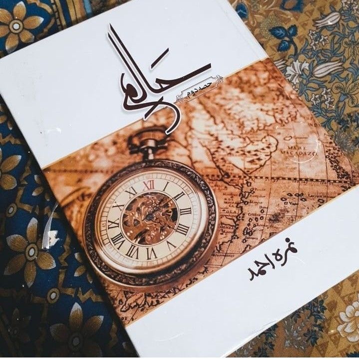 an old pocket watch sitting on top of a piece of paper with the arabic writing