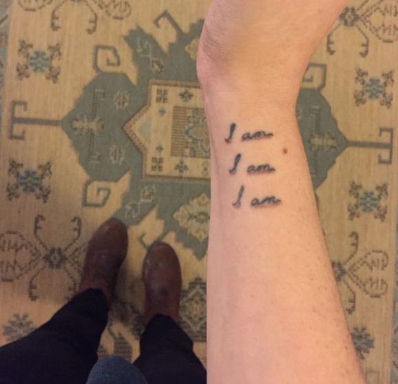 a person with a small tattoo on their arm saying i love you, ame