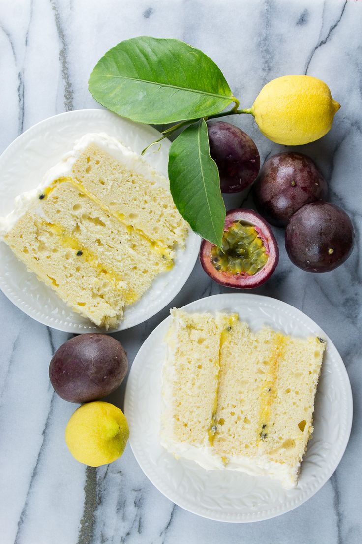 two plates with slices of cake and some fruit on the table next to each other