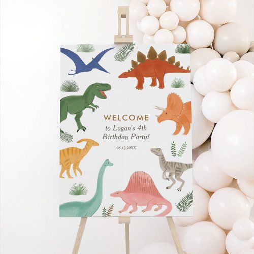 a welcome sign with dinosaurs on it next to balloons and white balls in the background