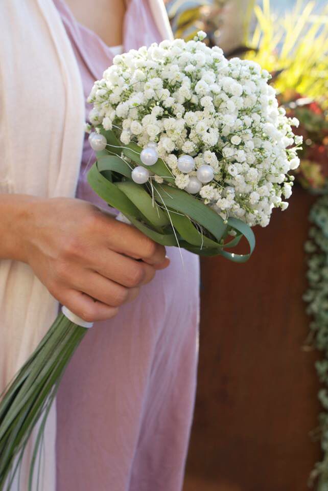 a woman holding a bouquet of white flowers