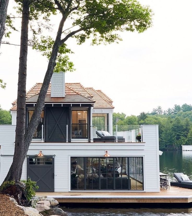 a houseboat is parked on the water next to a dock with a boat in it