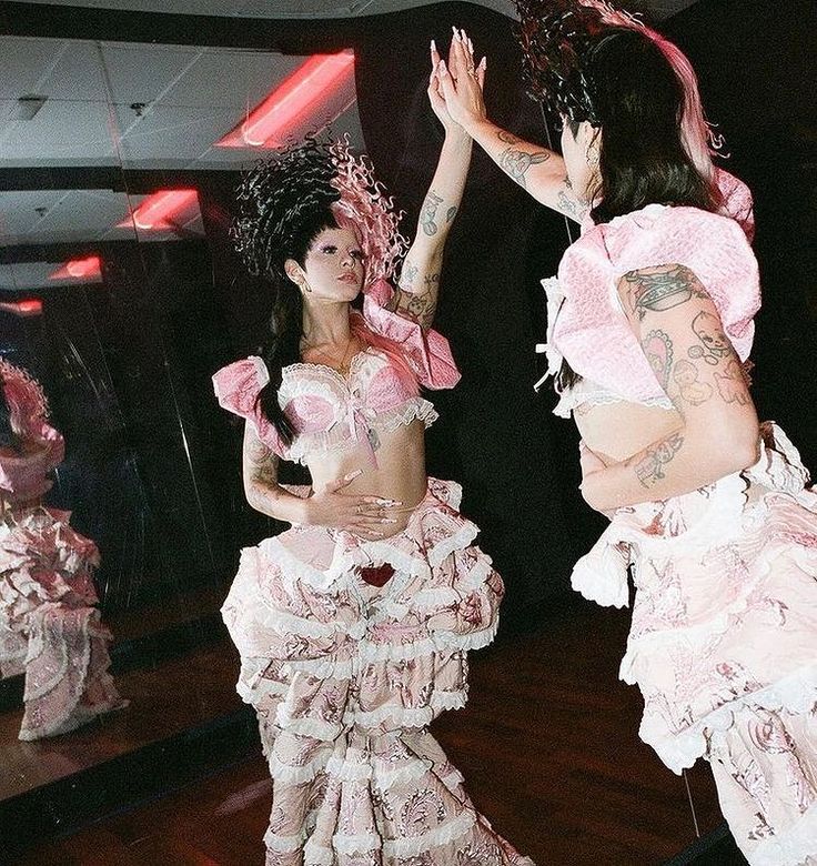 two women dressed in pink and white are dancing