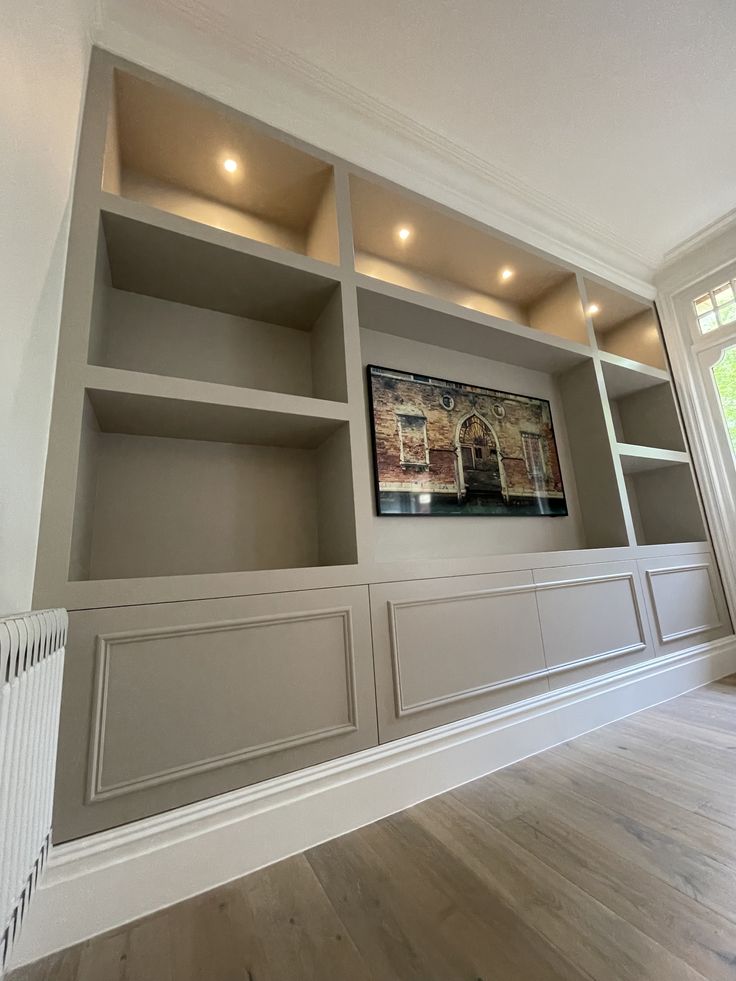 an empty room with built in bookshelves and wooden floors, painted gray by the paint company