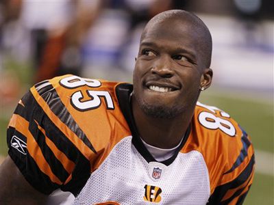 a close up of a football player wearing an orange and black uniform on the field