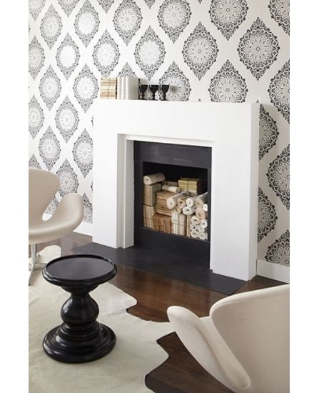 a white fireplace with black and white wallpaper